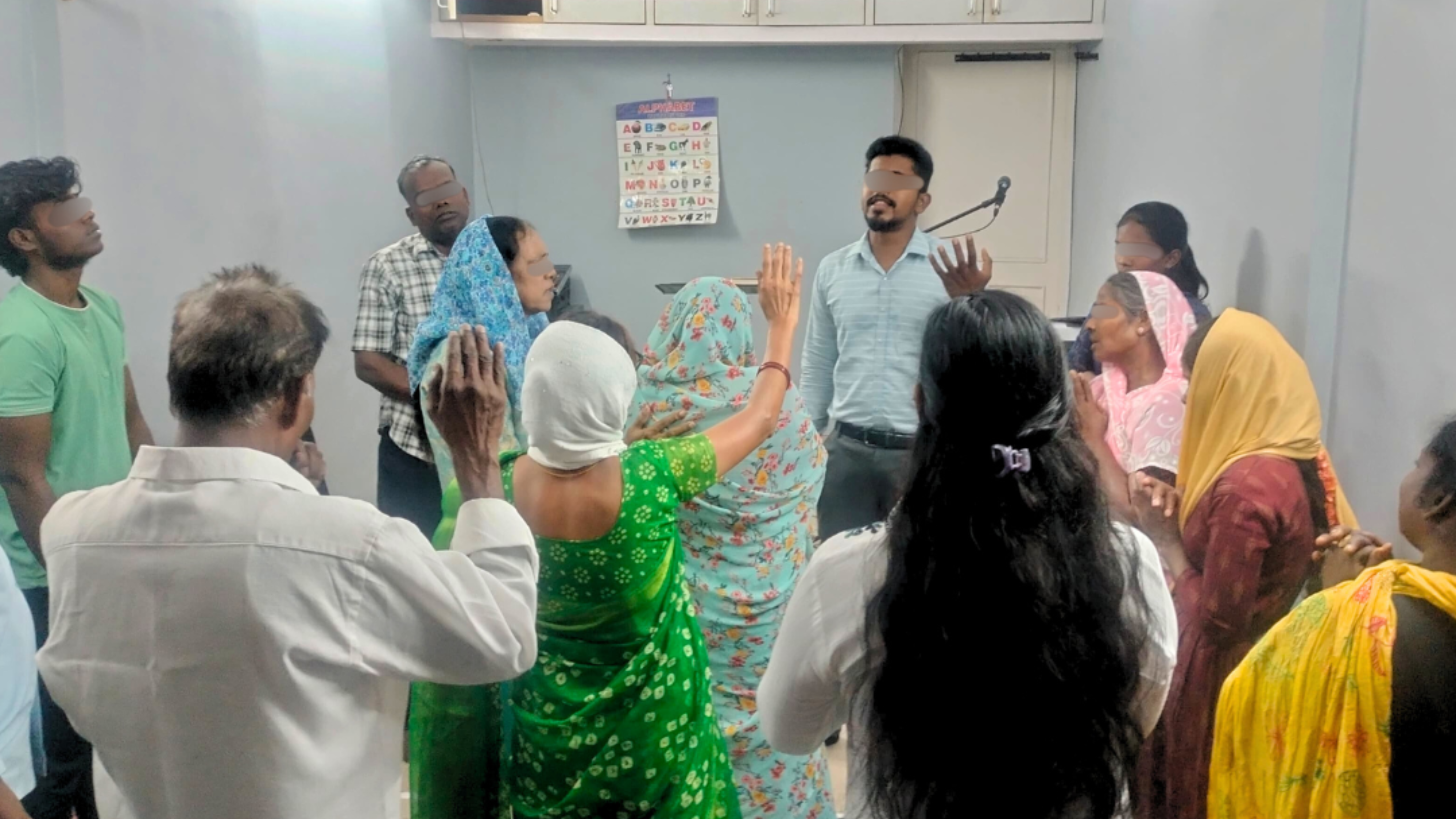 Group of church members raising hands in prayer.