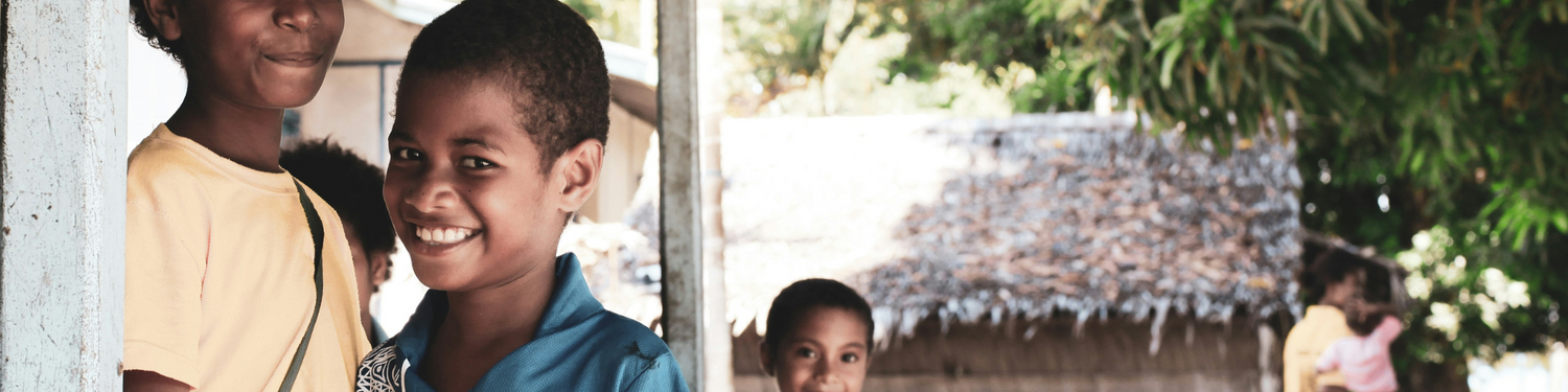 photo of children smiling at camera with green background