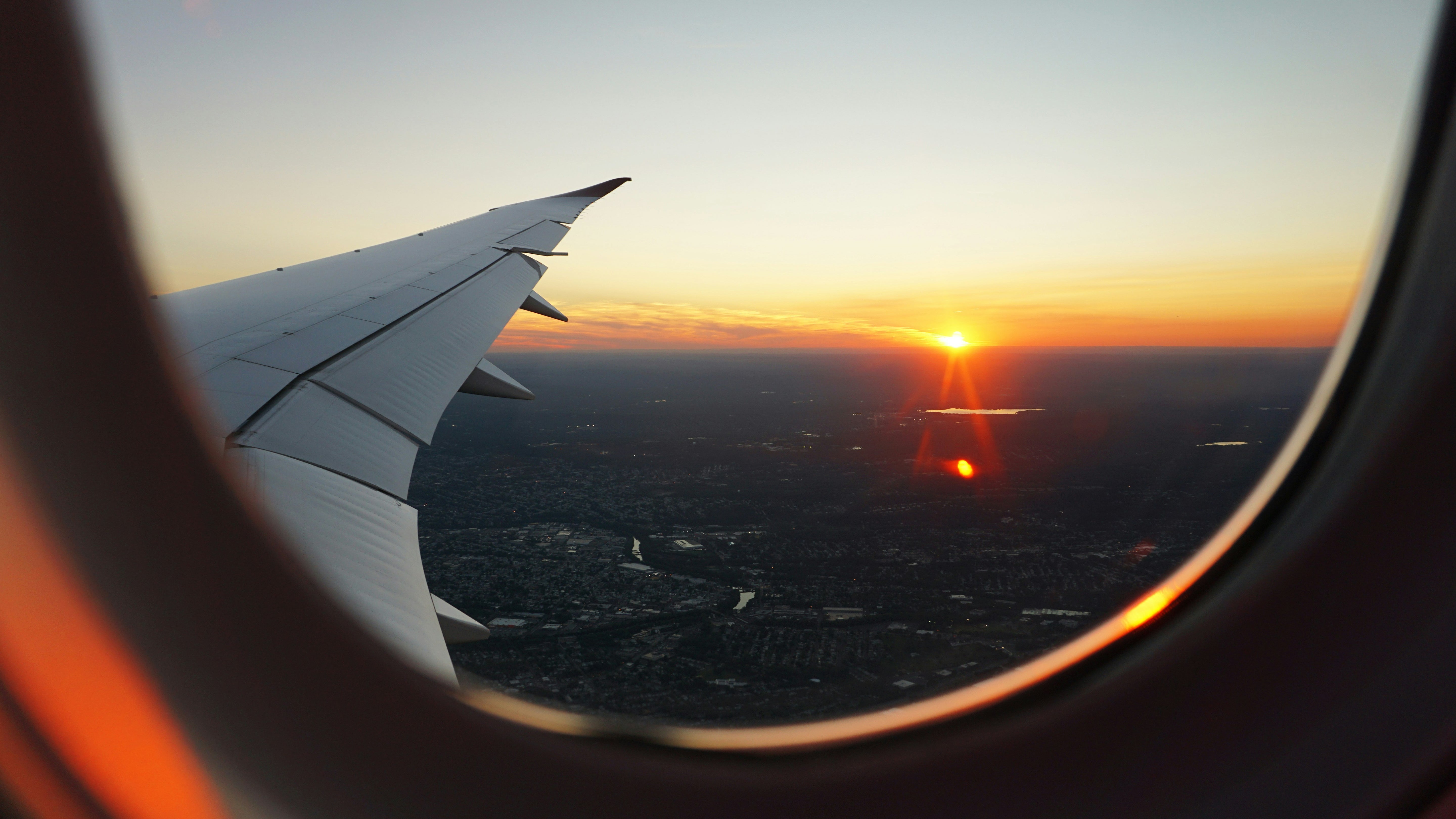 Airplane wing view from an airplane window during sunset.